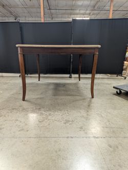 Stone Top Dining Table with Tapered Wood Legs has chip
