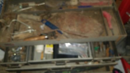 Old tool box has some tools it. Heavy tool box.