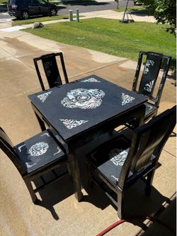 Korean-style set features a black lacquer finish with intricate mother-of-pearl inlay designs on the table and chairs.