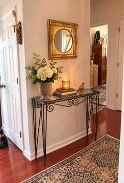 Beautiful wrought iron and glass console table with decorative scrollwork and slender iron legs. Very heavy, sturdy, and well made. The narrow design