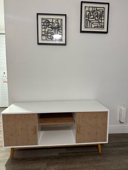 mid-century modern TV stand / media console with a white finish, wood-look doors, and tapered legs.  The measurements appear to be approximately:  * W