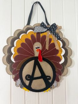 Hand-painted wooden Thanksgiving turkey door decoration, personalized with a monogram in the center. The design features a detailed turkey with colorf