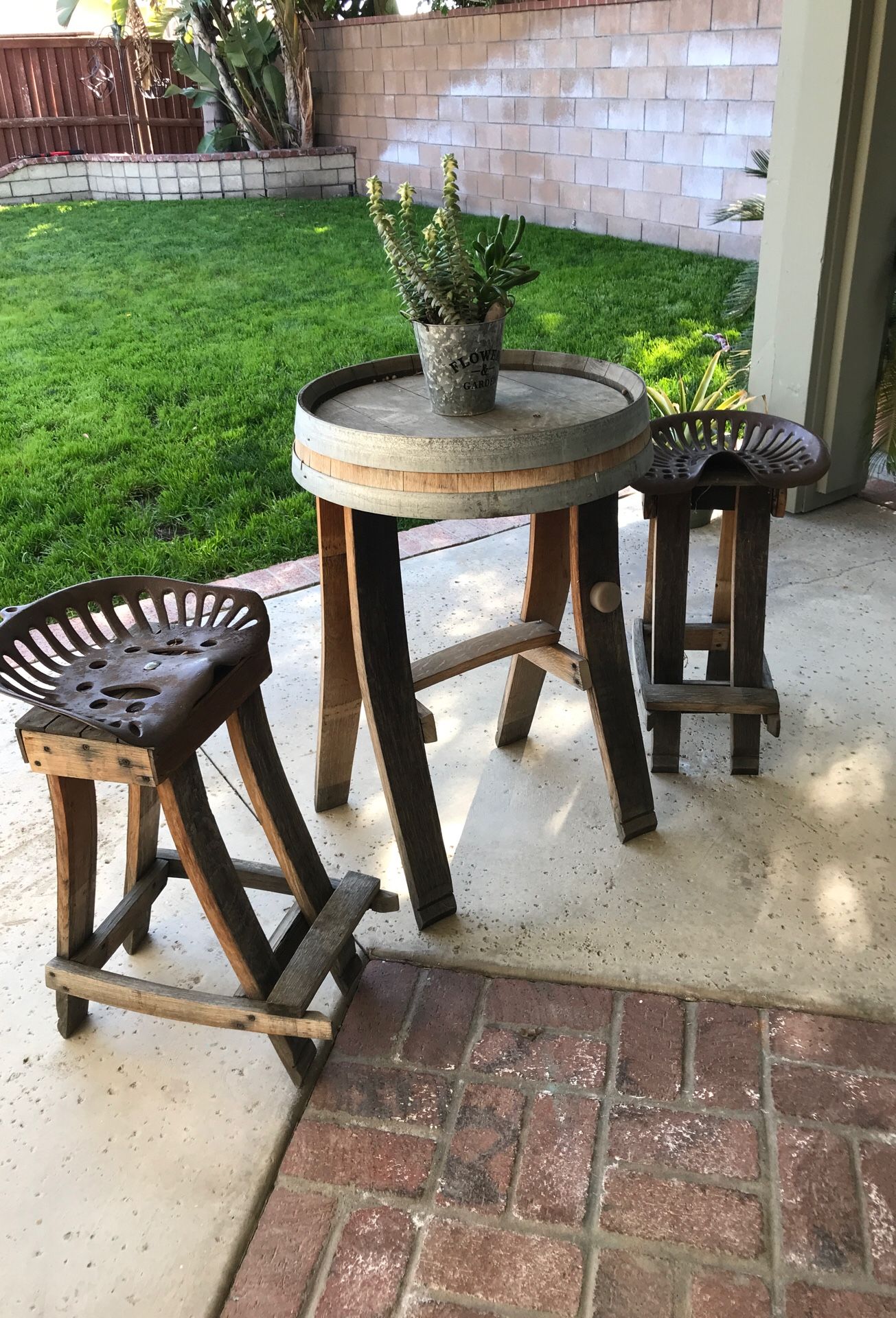 Wine Barrel table and two chairs with the tractor seats