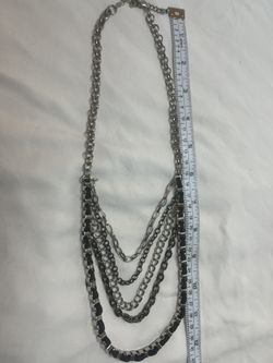 This is a Brighton Pebble Cascade necklace with several overlapping strands, featuring silver-plated chains and blued metal.
