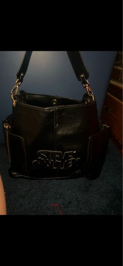 This black Steve Madden Bevelyn utility bag features a prominent embossed logo and side cargo pockets