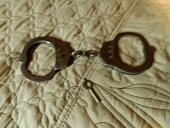 H. W. C. Vintage stainless steel hand cuffs with key.