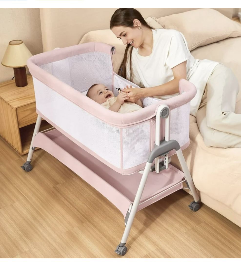 ANGELBLISS Flat Bedside Bassinet with Storage Basket, Easy Folding Portable Crib with Wheels, Included Breathable Mesh, Cozy Mattress(Pale Pink)