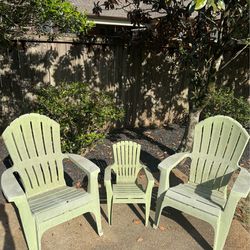 Set of three matching light‑green plastic Adirondack chairs