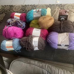 collection of various knitting and crocheting yarns from brands such as Loops & Threads, Plymouth Yarn