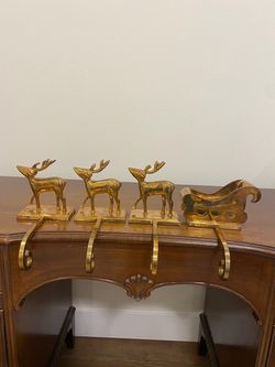 Vintage brass reindeer and sleigh stocking holders, set of four.