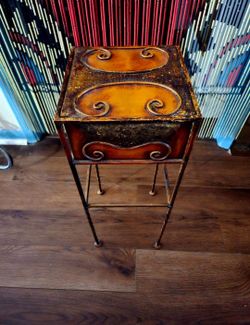 vintage-style wrought iron side table featuring a distressed, warm-toned hand-painted finish and decorative scrollwork.8.5"×22.5"
