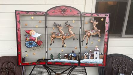 decorative, painted metal or wooden reindeer accent attached to a Christmas fireplace screen or holiday display