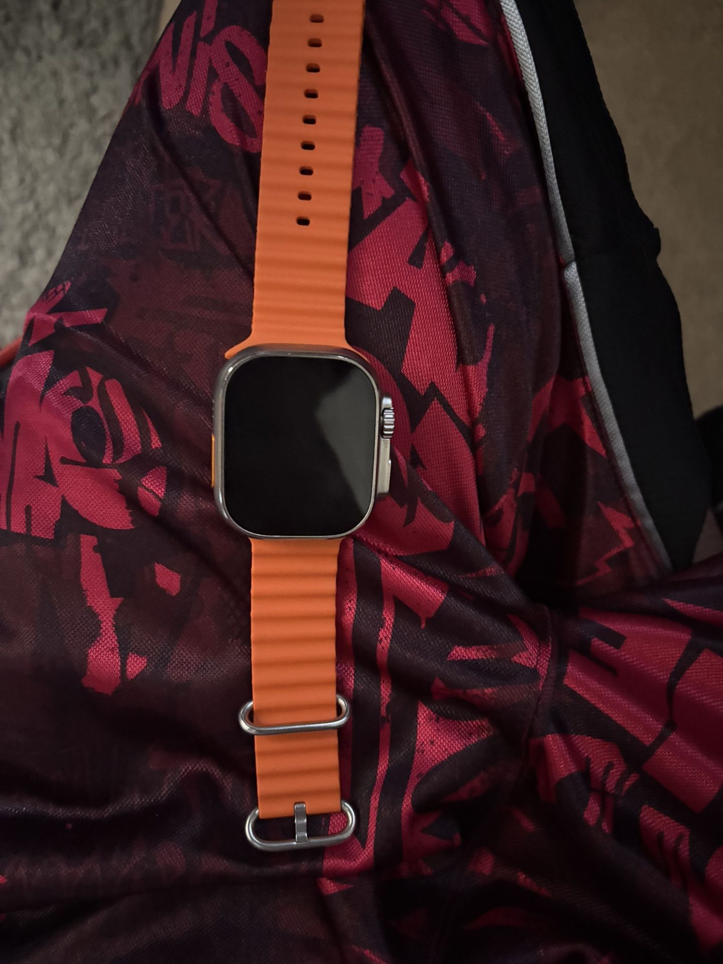 Apple Watch Ultra 2 with an orange Ocean Band.