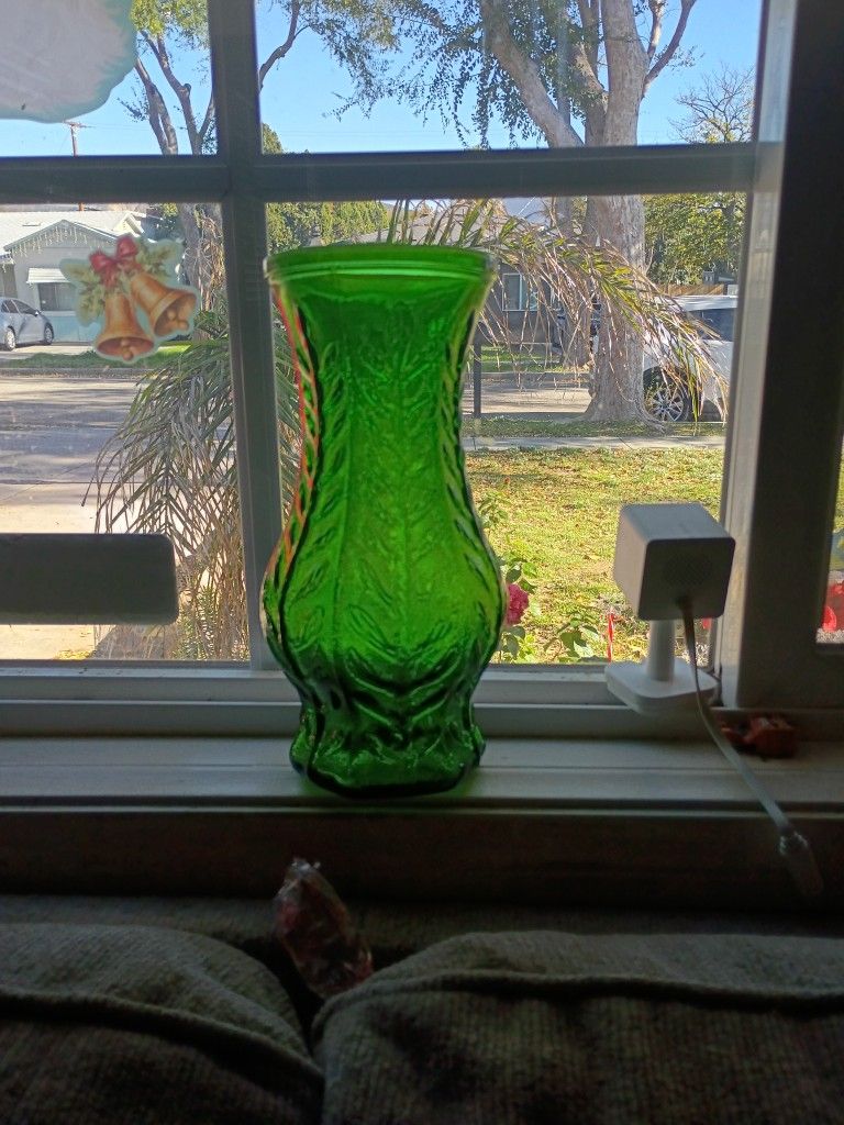 This is a vintage FTD emerald green glass vase with an embossed fern or leaf design. 
