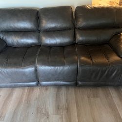 Wall hugger leather sofa with dual recliners