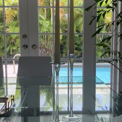 Add some elegance to your living space with this set of 2 clear glass candlesticks.