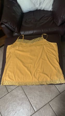 This mustard yellow camisole features delicate floral lace trim along the V-neckline and hem with adjustable spaghetti straps.