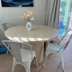 Circular dining table with chairs included and bottom storage compartment.