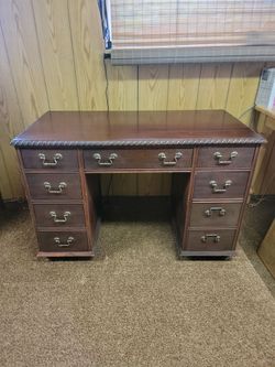 VINTAGE wooden double-pedestal executive desk featuring nine drawers, a carved rope-style top border, and traditional brass bail hardware pulls.