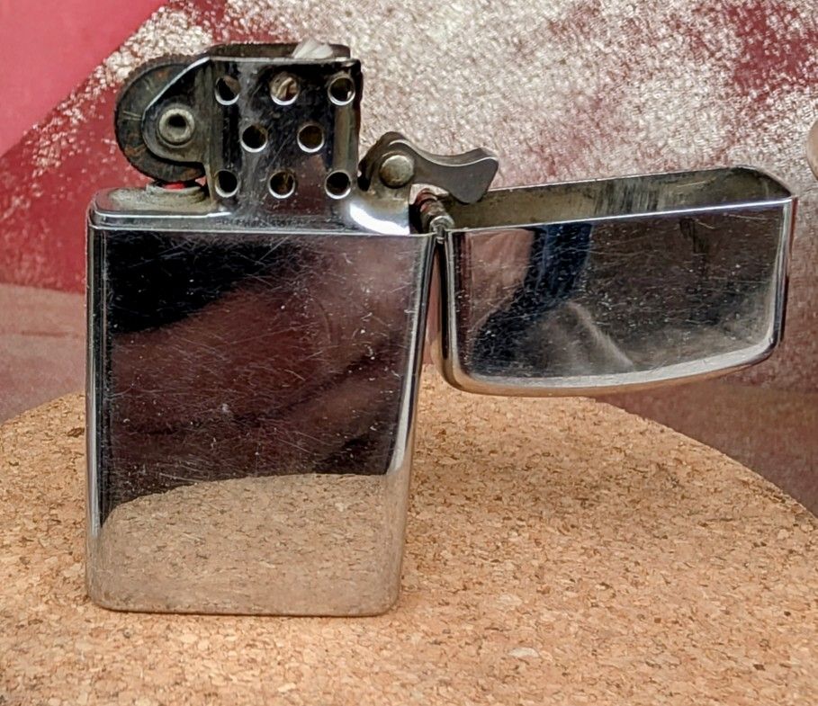 1970 Zippo Slim High Chrome Lighter (Good Working Condition). Has some visible wear and scratches.