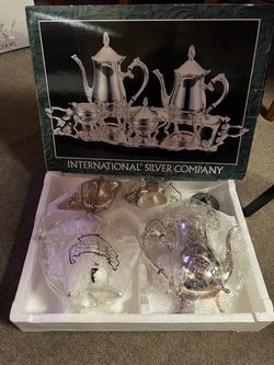 Four-piece silver-plated coffee set including: coffee pot, teapot, covered sugar bowl, and milk jug; does not include a tray.