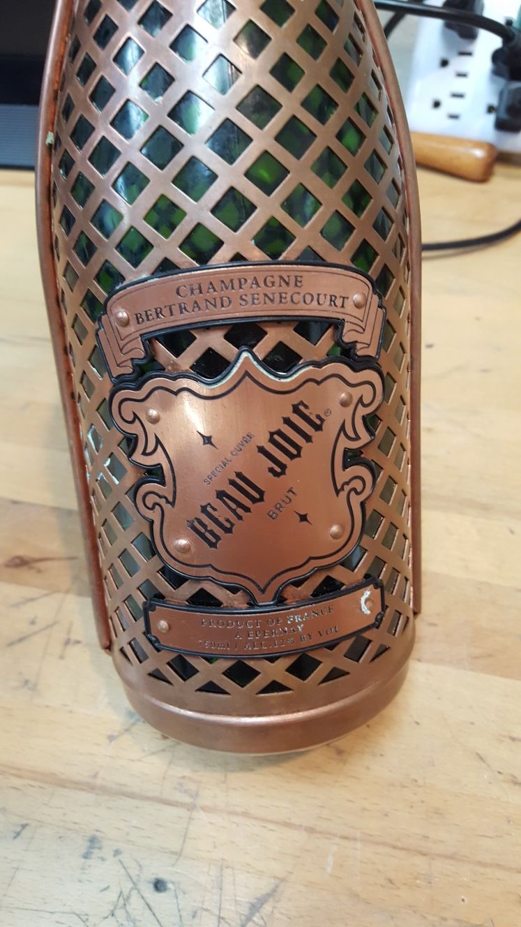 Vintage Empty glass champagne bottle wrapped in copper