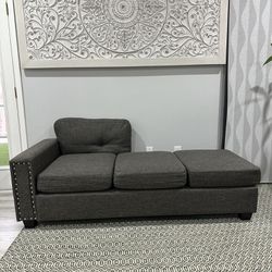 New Upholstered gray sofa with missing back and pillow. 74 inches long.