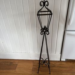 Tall wrought iron lantern stand, a decorative accent piece holds a single candle in middle