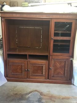 Large wood entertainment center with a center TV bay