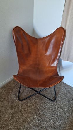 2 - Rustic brown leather butterfly chair with a black metal frame
