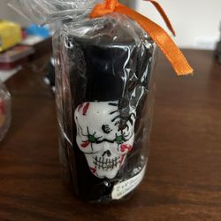 A 4 Inch Black Halloween Candle With Skeleton Face