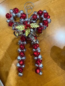 Festive jingle bell decoration with red and silver bells in shape of a bow