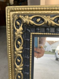 Mirror frame is hard plastic Looks wood 19 in accross 26 in tall