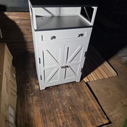 aparador compacto de estilo rústico moderno con acabado blanco y negro, diseñado para almacenamiento con cajón y puertas estilo granero. 