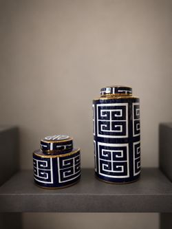 Tall blue and white porcelain lidded jar featuring a geometric Greek Key motif and gold rim accents.
