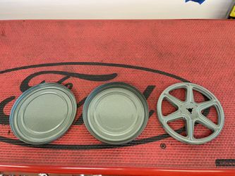 vintage metal 8mm film reel and canisters. They are collectible items for film enthusiasts. 
