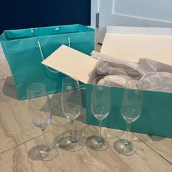 Perfect for showers and weddings!  Tiffany and Company, champagne flutes- four glasses .. We’re selling FOUR for $200.  Comes with original box and ba