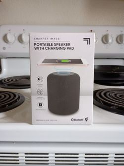 Portable speaker with charging pad