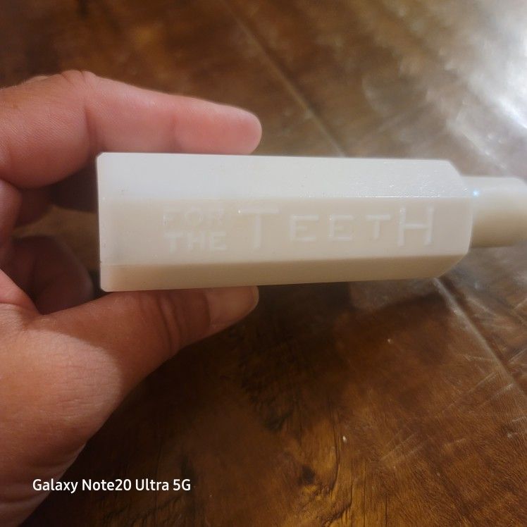 antique white milk glass bottle embossed with the words "SANITOL FOR THE TEETH".