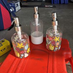 2 Glass hand soap dispensers and 1 dish soap dispenser