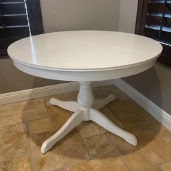 Round extendable wooden dining table