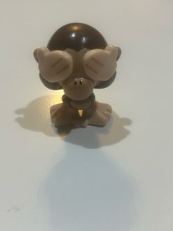 a "See No Evil" monkey toy, likely a small plastic collectible figurine or charm from lines like Emoji Stikeez, Vuala, or similar promotional blind-ba
