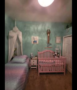 Used pink baby crib and mattress with mattress pad and sheet