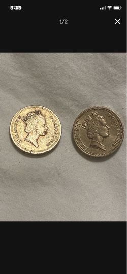 Two  British One Pound coin featuring the Latin phrase "DECUS ET TUTAMEN"