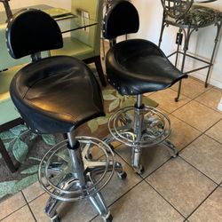 A set of vintage seats, Harley Davidson, motorcycle saddle, seat, and chrome with rolling rolling wheels