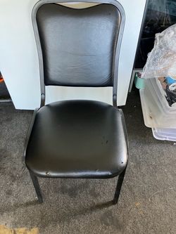 12 black vinyl upholstered commercial stack chair with a metal frame