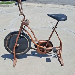 Vintage 1970s Schwinn Exerciser stationary bike, likely in the "Coppertone" bronze finish. 