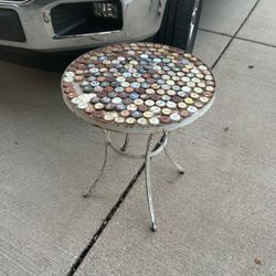 Accent table 21”T 18”D made from assorted bottle caps in a round white-painted metal frame and legs