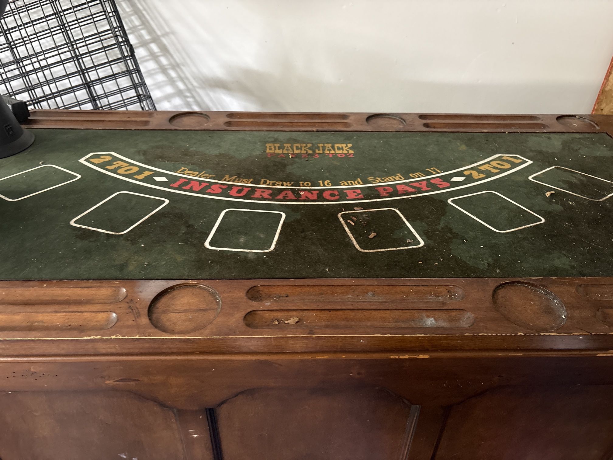 Vintage wooden blackjack table with card slots.