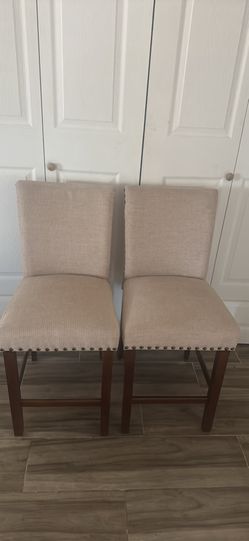 Pair of cream colored upholstered countertop stools